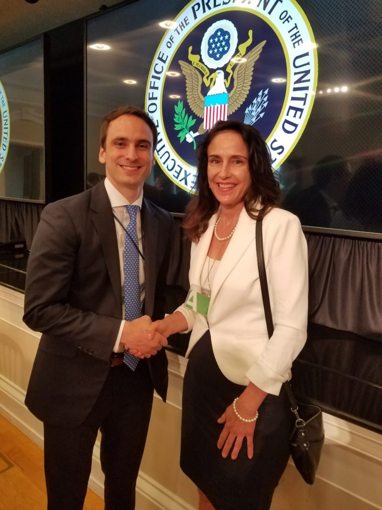 Carol Lynn Grow shakes hands with Michael Kratsios, former Chief Technology Officer of the United States.