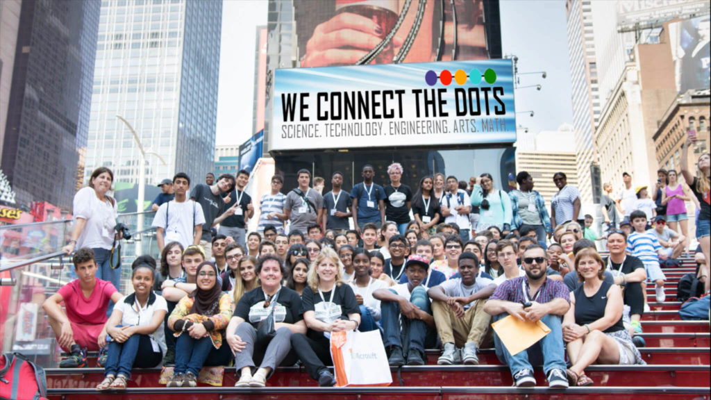 Laurie Carey sits with volunteers and student participants at We Connect the Dots (Science, Technology, Engineering, Arts, Math) conference in Times Square.